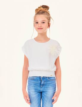 Blusa bianca in crêpe con punto smock in vita e applicazione floreale