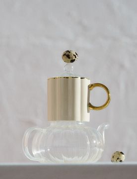 Tazza in ceramica con superficie scanalata e manico dorato - beige